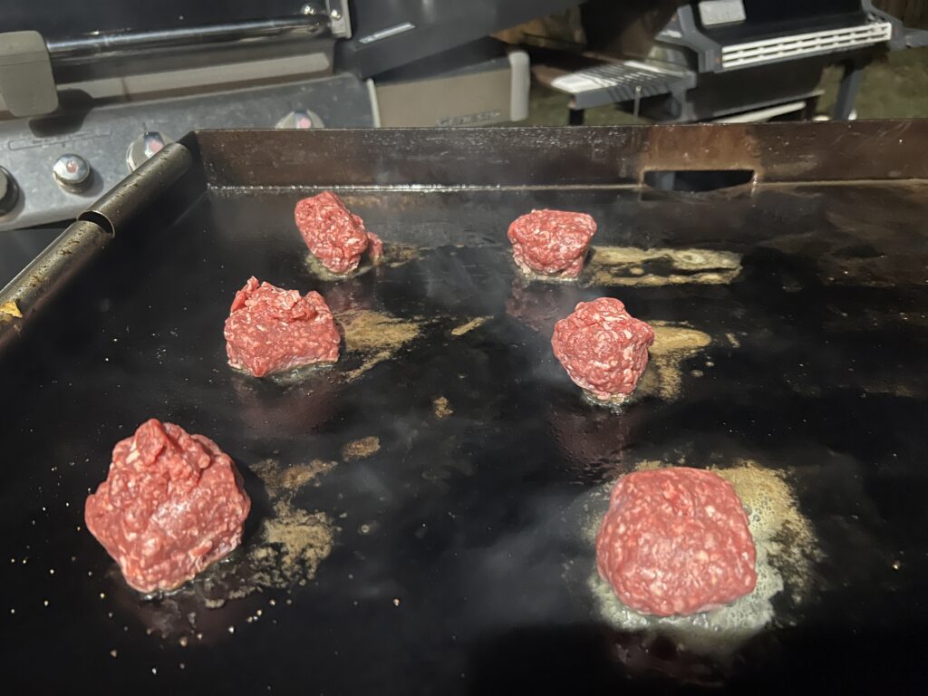 Raw portioned beef balls on the Blackstone griddle before smashing