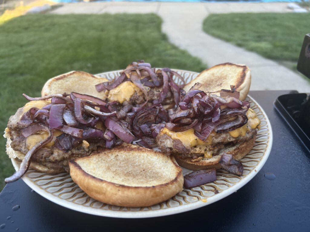 Beef smash burger topped with grilled red onion and sharp cheddar
