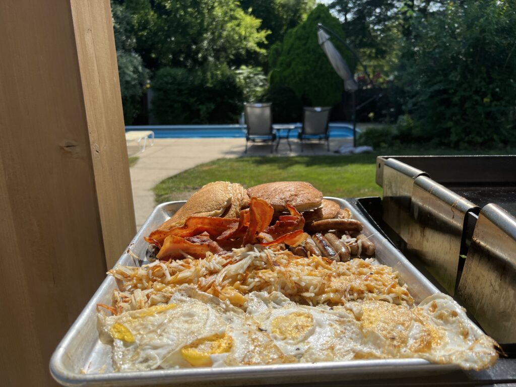 The finished platter — pancakes, bacon, sausage, hash browns, and eggs on a sheet pan