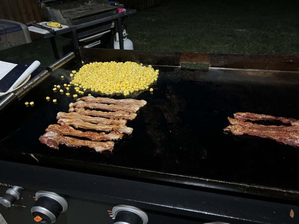 Bacon and canned corn cooking on the Blackstone